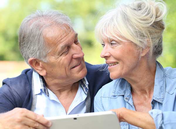 Pareja feliz de usar una tableta Facilotab.